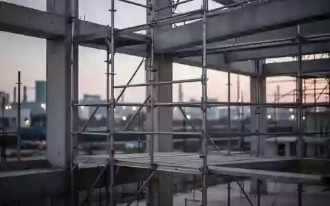 Ein leeres Stahlgerüst auf einer modernen Baustelle bei Dämmerung, das die industrielle Umgebung und Baustruktur zeigt. - Foto: über boerse-global.de
