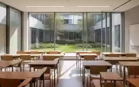 Ein heller, leerer Unterrichtsraum in einer Universität mit sauberen Holztischen und Blick in einen grünen Innenhof. - Foto: über boerse-global.de