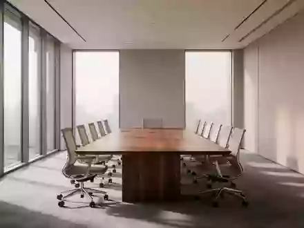 Ein minimalistisch eingerichteter, moderner Konferenzraum mit einem langen Holztisch und ordentlich angeordneten Stühlen. - Foto: über boerse-global.de