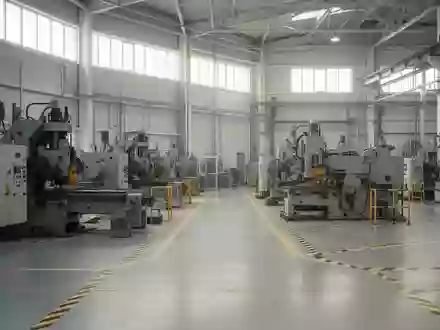 Leere Industriehalle mit modernen Maschinen und Sicherheitsmarkierungen auf dem Boden bei natürlichem Lichteinfall. - Foto: über boerse-global.de
