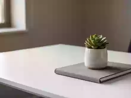 Ein minimalistischer, leerer Schreibtisch mit einer kleinen Sukkulente und einem Notizbuch in hellem Tageslicht. - Foto: über boerse-global.de