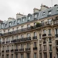 Historische Pariser Wohnfassade mit Balkonen aus Schmiedeeisen unter einem bewölkten Himmel. - Foto: über boerse-global.de
