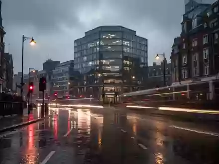 Eine verregnete Straße im Londoner Stadtteil King's Cross bei Dämmerung mit Lichtreflexionen auf nassem Asphalt. - Foto: über boerse-global.de