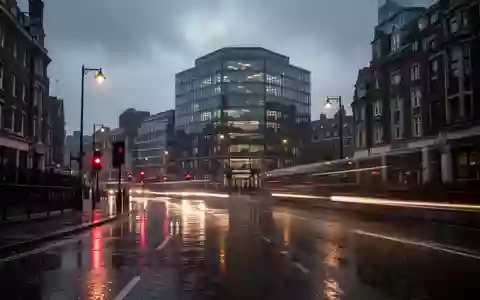 Eine verregnete Straße im Londoner Stadtteil King's Cross bei Dämmerung mit Lichtreflexionen auf nassem Asphalt. - Foto: über boerse-global.de