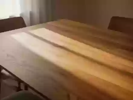 Ein minimalistischer Holztisch in hellem Tageslicht, der eine ruhige und geordnete Essumgebung zur Mittagszeit darstellt. - Foto: über boerse-global.de