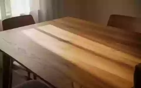 Ein minimalistischer Holztisch in hellem Tageslicht, der eine ruhige und geordnete Essumgebung zur Mittagszeit darstellt. - Foto: über boerse-global.de