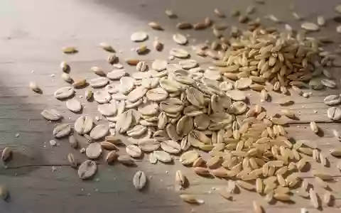 Nahaufnahme von verschiedenen Vollkorngetreidesorten wie Haferflocken und Naturreis auf einer rustikalen Holzoberfläche. - Foto: über boerse-global.de
