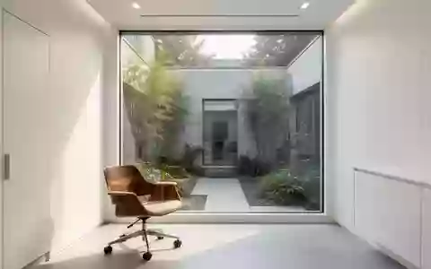 Ein minimalistischer, lichtdurchfluteter Behandlungsraum in einer modernen medizinischen Einrichtung mit Blick in einen Innenhof. - Foto: ĂĽber boerse-global.de