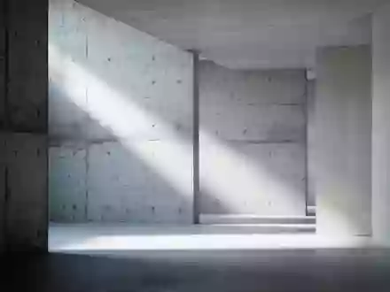 Abstrakte, minimalistische Innenarchitektur mit klaren Linien und natürlichem Lichtspiel auf Betonoberflächen. - Foto: über boerse-global.de