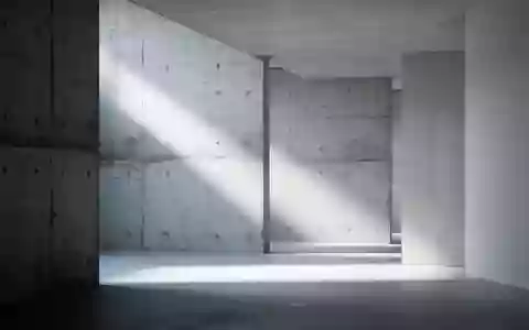 Abstrakte, minimalistische Innenarchitektur mit klaren Linien und natürlichem Lichtspiel auf Betonoberflächen. - Foto: über boerse-global.de