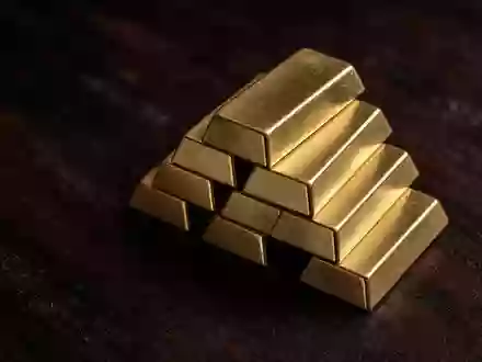 Goldbarren auf einer dunklen Holzoberfläche in einer professionellen, neutralen Aufnahme. - Foto: über boerse-global.de