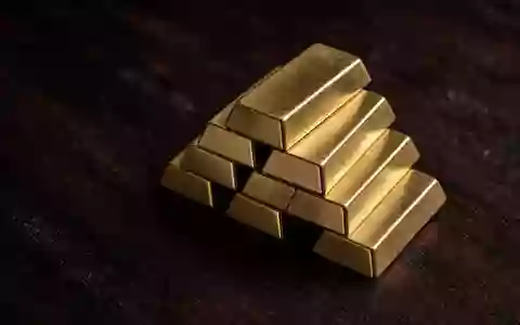 Goldbarren auf einer dunklen Holzoberfläche in einer professionellen, neutralen Aufnahme. - Foto: über boerse-global.de