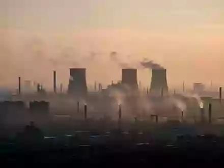 Dunstige Industrielandschaft bei Dämmerung, die die Auswirkungen von Luftverschmutzung und Feinstaub visualisiert. - Foto: über boerse-global.de