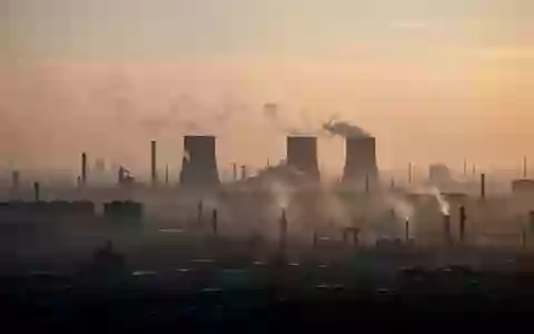 Dunstige Industrielandschaft bei Dämmerung, die die Auswirkungen von Luftverschmutzung und Feinstaub visualisiert. - Foto: über boerse-global.de