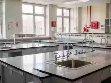 Ein leerer naturwissenschaftlicher Fachraum in einer Schule mit Arbeitstischen und Gasanschlüssen bei Tageslicht. - Foto: über boerse-global.de