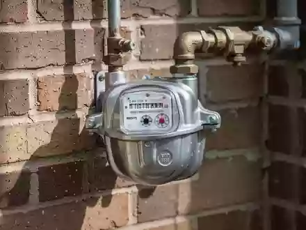 Ein Wasserzähler an einer Ziegelwand, der die Infrastruktur für kommunale Nebenkosten symbolisiert. - Foto: über boerse-global.de