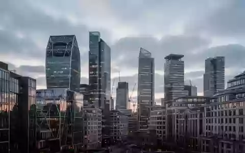 Moderne Bürogebäude in der Londoner Skyline bei Dämmerung, die die städtische Infrastruktur und Architektur verdeutlichen. - Foto: über boerse-global.de