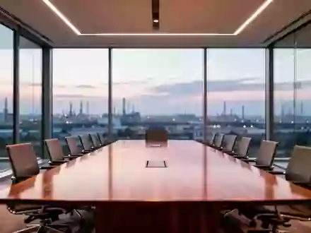 Ein minimalistischer, moderner Konferenzraum mit einem großen Holztisch vor einer Fensterfront mit Blick auf eine Industrielandschaft. - Foto: über boerse-global.de