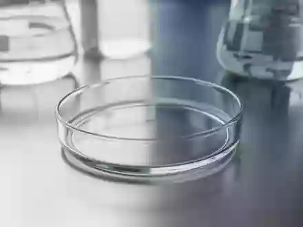 Ein leeres, steriles Laborglas auf einer Edelstahloberfläche, im Hintergrund unscharfe Laborgläser in einer klinischen Umgebung. - Foto: über boerse-global.de