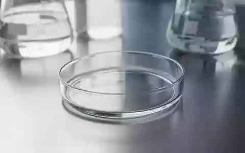 Ein leeres, steriles Laborglas auf einer Edelstahloberfläche, im Hintergrund unscharfe Laborgläser in einer klinischen Umgebung. - Foto: über boerse-global.de