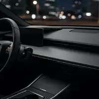 Dunkles, minimalistisches Armaturenbrett eines Autos mit Fokus auf Oberflächen und Materialien ohne sichtbare Bildschirme. - Foto: über boerse-global.de