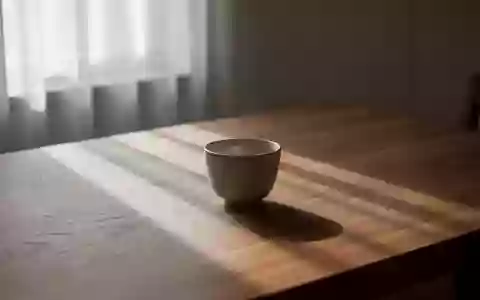 Ein minimalistischer Raum mit sanftem Tageslicht und einer leeren Keramiktasse auf einem Holztisch, der Ruhe ausstrahlt. - Foto: über boerse-global.de