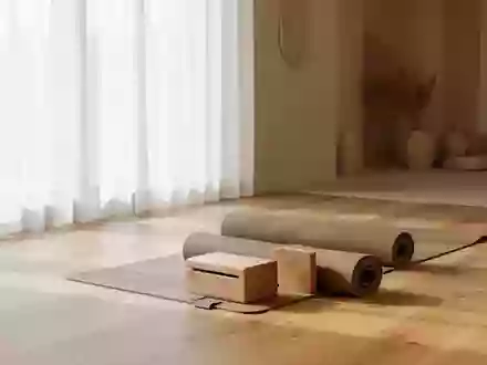 Ein minimalistischer, heller Übungsraum mit einer Yogamatte und einem Holzblock auf einem Holzboden. - Foto: über boerse-global.de