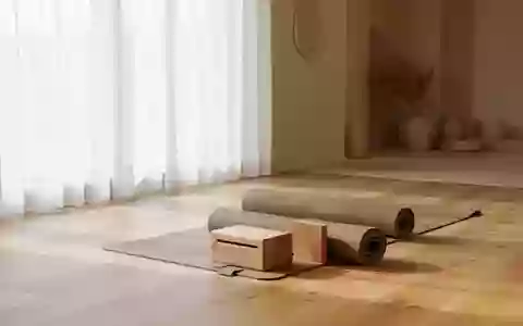 Ein minimalistischer, heller Übungsraum mit einer Yogamatte und einem Holzblock auf einem Holzboden. - Foto: über boerse-global.de