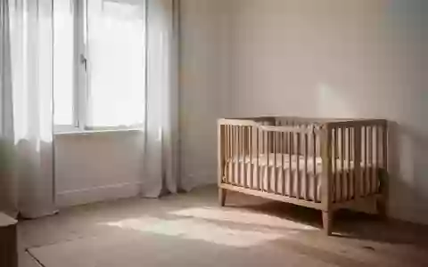 Ein helles, minimalistisch eingerichtetes Kinderzimmer mit sanftem Tageslicht, Holzmöbeln und hellem Holzboden. - Foto: über boerse-global.de