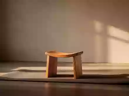 Ein ruhiger, minimalistischer Raum mit einer Meditationsmatte und einem Holzhocker in sanftem, warmem Tageslicht. - Foto: über boerse-global.de