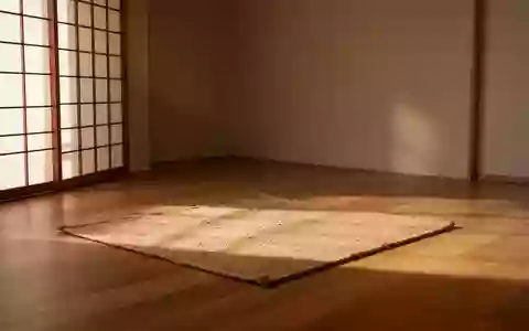 Ein minimalistischer Meditationsraum mit einer schlichten Matte auf einem Holzboden in hellem, natürlichem Licht. - Foto: über boerse-global.de