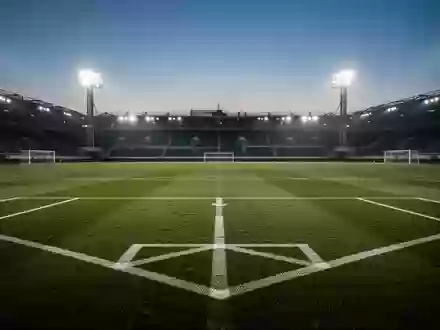 Ein leerer Fußballplatz bei Flutlicht in der Dämmerung, der den Fokus auf Prävention und Gesundheitsaufklärung symbolisiert. - Foto: über boerse-global.de