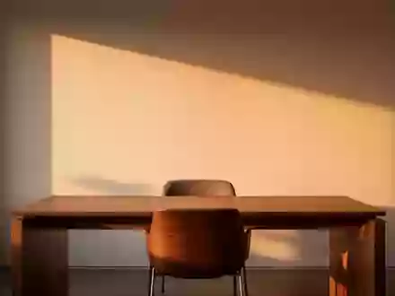 Ein minimalistischer, ruhiger Büroarbeitsplatz mit leerem Stuhl in warmem Licht, der eine Atmosphäre von Besonnenheit ausstrahlt. - Foto: über boerse-global.de