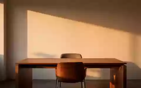 Ein minimalistischer, ruhiger Büroarbeitsplatz mit leerem Stuhl in warmem Licht, der eine Atmosphäre von Besonnenheit ausstrahlt. - Foto: über boerse-global.de