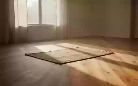 Ein minimalistischer, von sanftem Tageslicht durchfluteter Raum mit einem schlichten Bodenbelag und einer leeren Matte. - Foto: über boerse-global.de