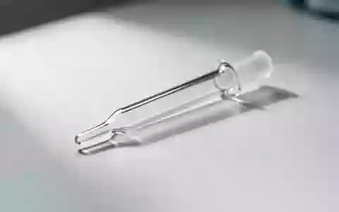 Eine medizinische Pipette auf einer sterilen weißen Laboroberfläche als Symbol für wissenschaftliche Stoffwechselanalysen. - Foto: über boerse-global.de