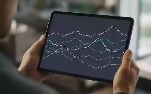 Hände halten ein Tablet mit einer abstrakten Grafik zur Darstellung globaler Markttrends in einer Büroumgebung. - Foto: über boerse-global.de