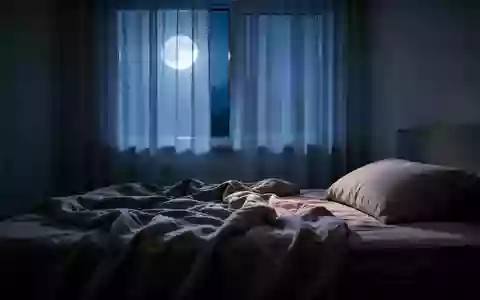 Ein ungemachtes Bett in einem ruhig beleuchteten Schlafzimmer bei Nacht, das eine Atmosphäre der Entspannung vermittelt. - Foto: über boerse-global.de