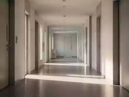 Ein minimalistischer, heller Flur einer medizinischen Praxis mit klaren architektonischen Linien und natürlichem Licht. - Foto: über boerse-global.de