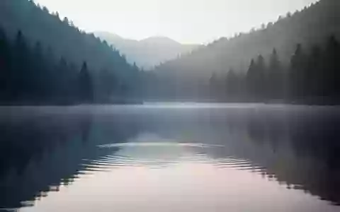 Ein ruhiger Bergsee im sanften Licht der Morgendämmerung, der eine Atmosphäre von Stille und Gelassenheit vermittelt. - Foto: über boerse-global.de