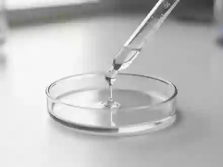Eine Laborpipette gibt eine Flüssigkeit in eine Petrischale auf einem sauberen, weißen Labortisch. - Foto: über boerse-global.de