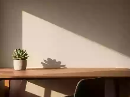 Ein minimalistischer, sonnendurchfluteter Schreibtisch in einem modernen Büro mit einer kleinen Pflanze und weichem Licht. - Foto: über boerse-global.de