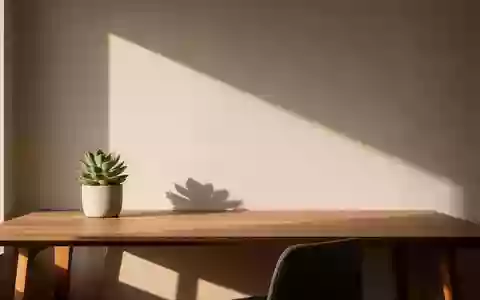 Ein minimalistischer, sonnendurchfluteter Schreibtisch in einem modernen Büro mit einer kleinen Pflanze und weichem Licht. - Foto: über boerse-global.de