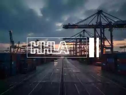Ein moderner Containerhafen mit Kränen und gestapelten Containern in einer stimmungsvollen Dämmerung. - Foto: über boerse-global.de