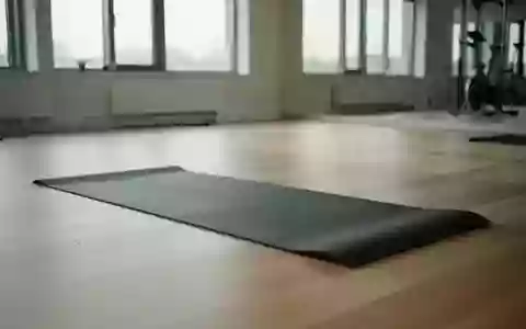 Eine saubere, minimalistische Trainingsumgebung mit einer einzelnen Yogamatte auf einem hellen Holzboden in einem lichtdurchfluteten Raum. - Foto: über boerse-global.de