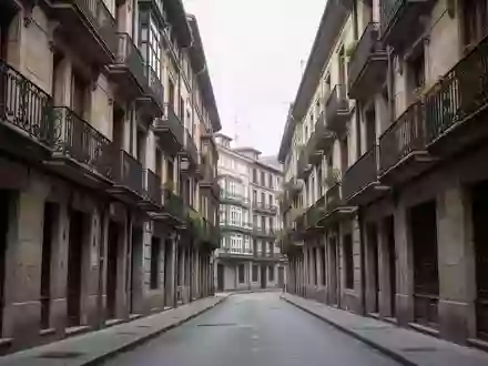 Eine ruhige Wohnstraße mit traditionellen Steingebäuden und schmiedeeisernen Balkonen in einem Viertel von Bilbao. - Foto: über boerse-global.de