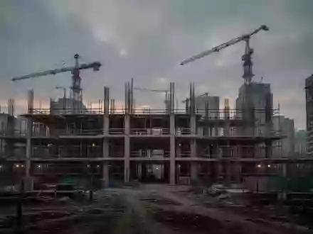 Eine leere Baustelle mit Baugerüsten und Kränen vor einem bewölkten Himmel in einer deutschen Universitätsstadt. - Foto: über boerse-global.de