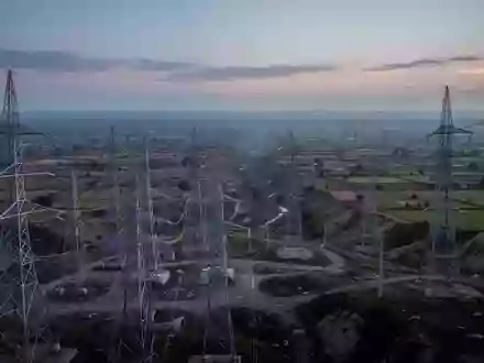 Eine weitläufige Landschaft, die den Kontrast zwischen moderner Energieinfrastruktur und einer unerschlossenen Region zeigt. - Foto: über boerse-global.de