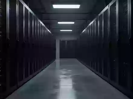 Dunkler, industrieller Serverraum mit langen Reihen anonymer Server-Racks in einer kühlen, technologischen Umgebung. - Foto: über boerse-global.de