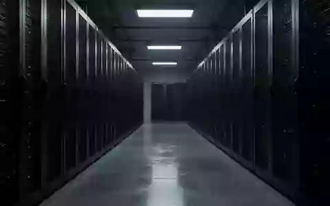 Dunkler, industrieller Serverraum mit langen Reihen anonymer Server-Racks in einer kühlen, technologischen Umgebung. - Foto: über boerse-global.de